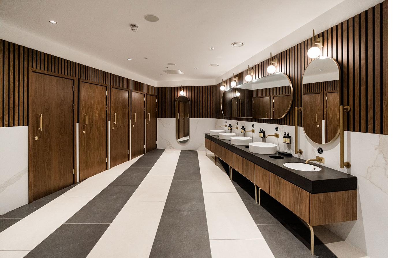Walnut and brass WC joinery with a stone vanity run